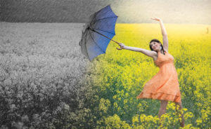 Girl holding umbrella in flower field